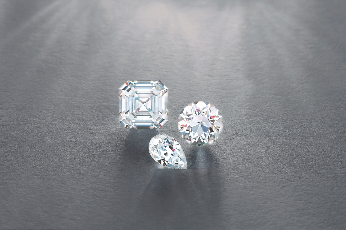 Loose Gemstones on gray background white sapphire engagement rings blog post by Soha Diamond Co. Jewelry Store in Madison, WI