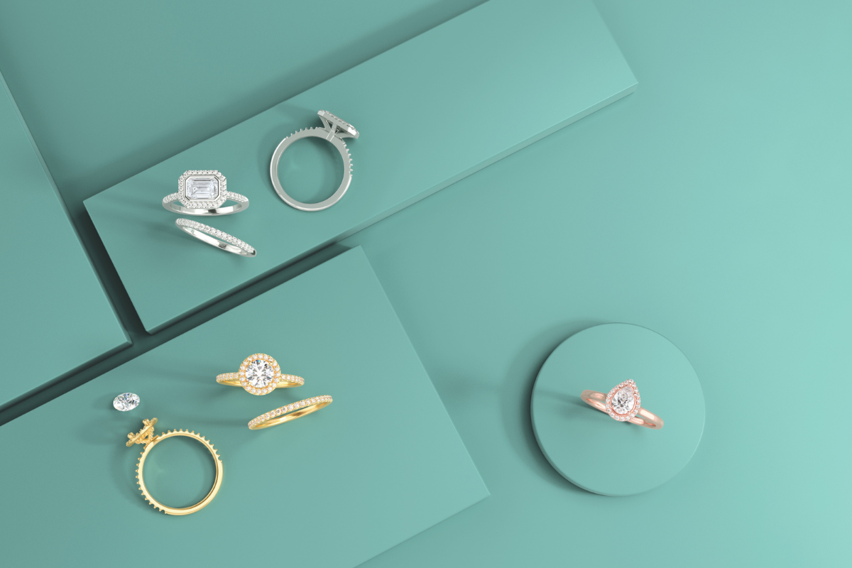 Rings on blue background - can you insure moissanite and lab grown diamond engagement rings - Soha Diamond Co. Jewelry Store in Madison, WI