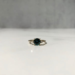 Yellow gold three-stone ring with round teal sapphire center