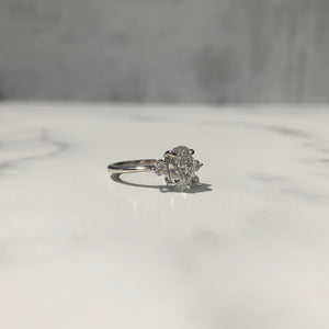 Platinum three-stone ring with oval diamond center