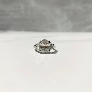Half-moon three stone engagement ring with oval center stone