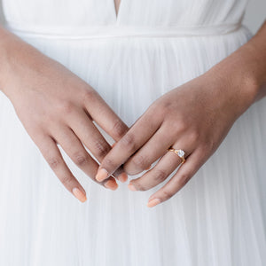 Bride wears yellow gold solitaire ring with cushion cut center