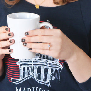 Twisted band engagement ring holding coffee cup