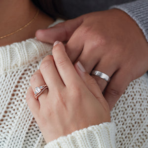 Woman in sweater wears rose gold three stone engagement ring